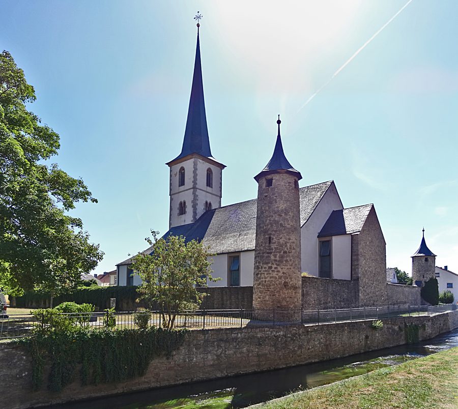 Kirchenburg St. Michael in Heustreu mit der Streu im Vordergrund