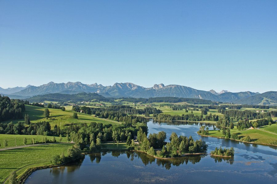 Schwaltenweiher bei Rückholz mit den Allgäuer und Tiroler Tannheimer Bergen im Hintergrund