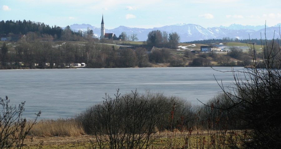 Soyensee bei Soyen mit der Filialkirche Mariä Himmelfahrt und den Chiemgauer Alpen im Hintergrund
