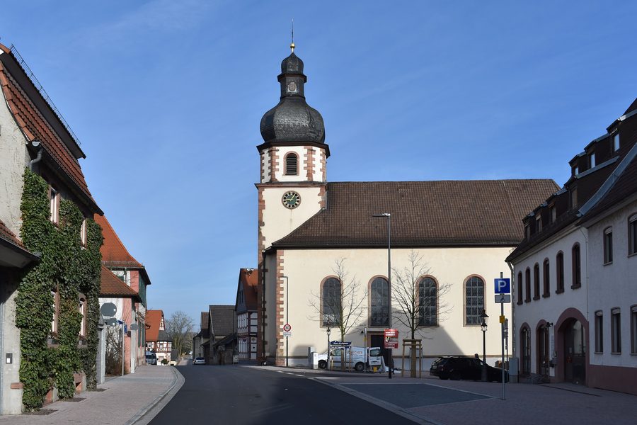 Blick durch die Hauptstraße von Stockstadt am Main auf die katholische Kirche St. Leonhard
