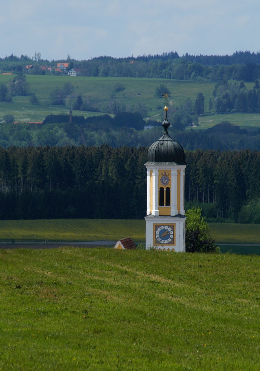 Blick auf den Kirchturm von Mauerstetten am Reutwaldpfad