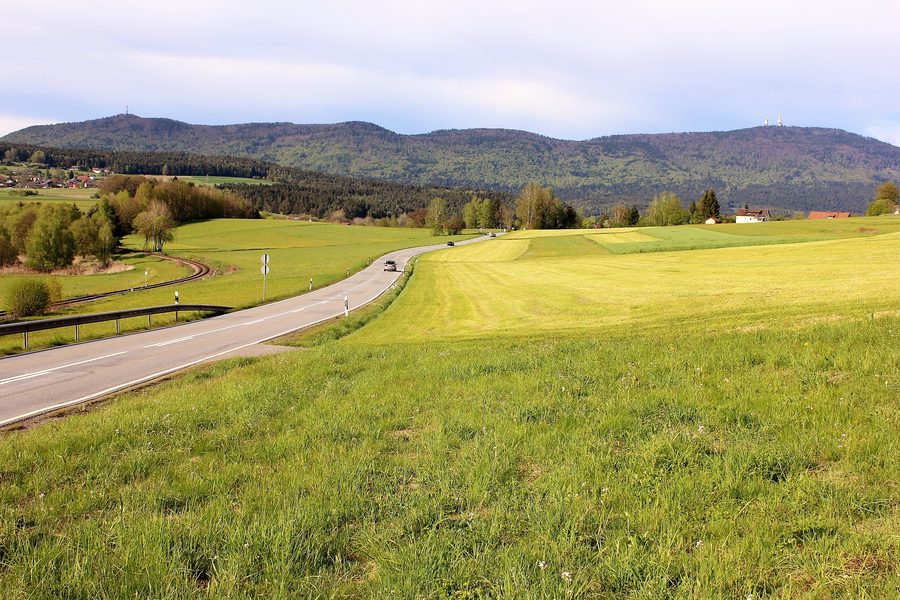 Blick von Grafenwiesen auf den Bergrücken des Hohen Bogen mit Bahnlinie im Vordergrund