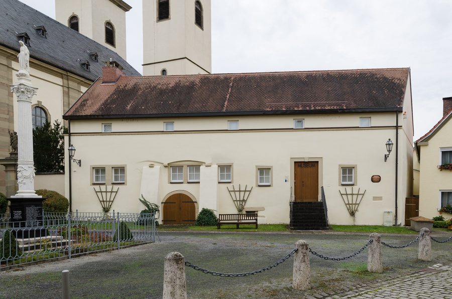 Historischer Kirchplatz in Grafenrheinfeld mit dem Alten Brauhaus und den Türmen der Pfarrkirche Kreuzauffindung