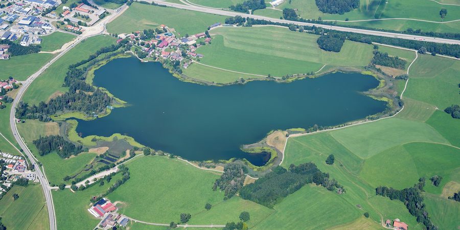 Luftaufnahme des Sulzberger Sees mit voralpiner Landschaft