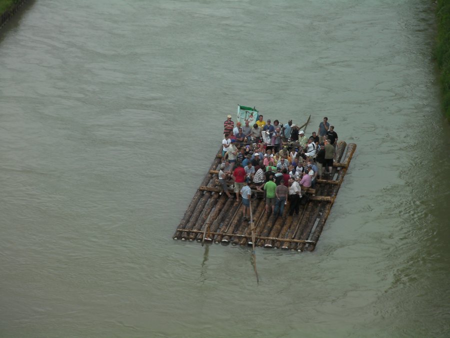 Holzfloß mit Ausflüglern auf einem Fluss in Bayern